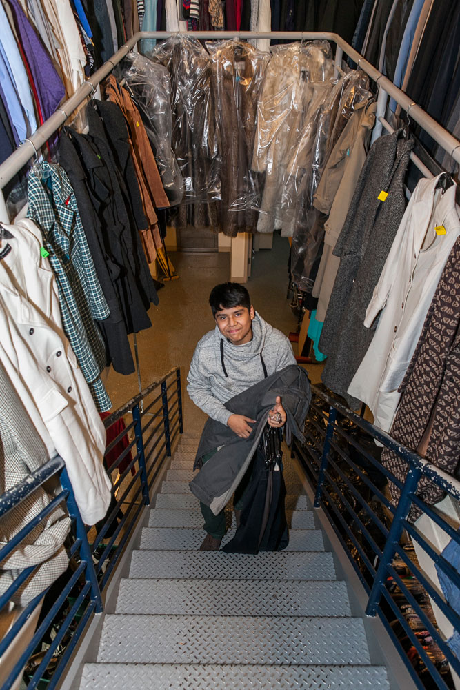 Jonathan bringing out clothing to stock on the shelves of The Sharing Place.